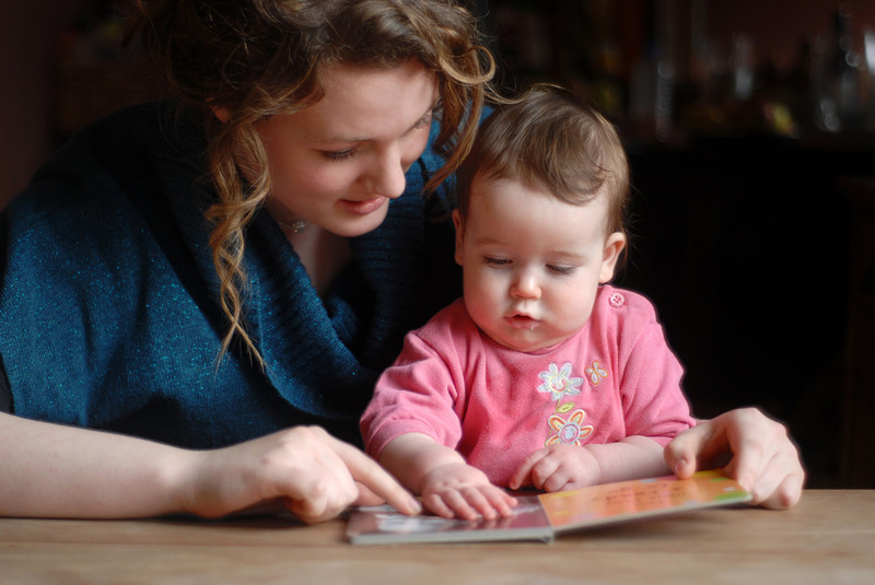 adulte avec bébé et livre