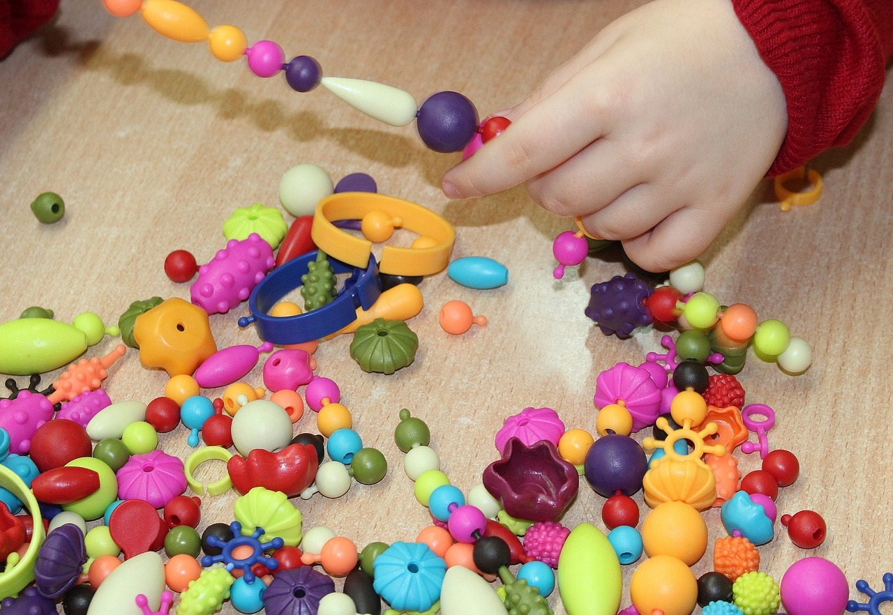 enfant qui enfile des perles