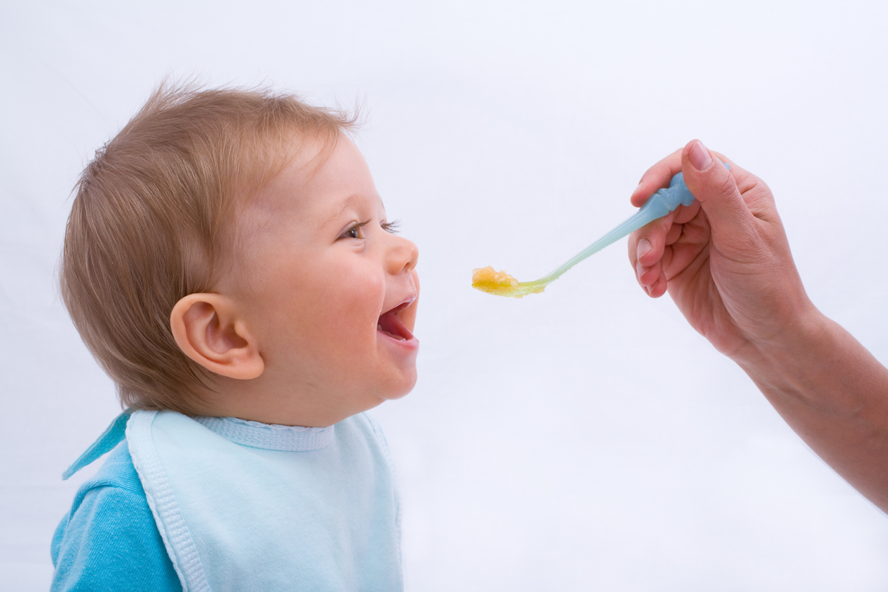 enfant mange premiers morceaux à la cuiller