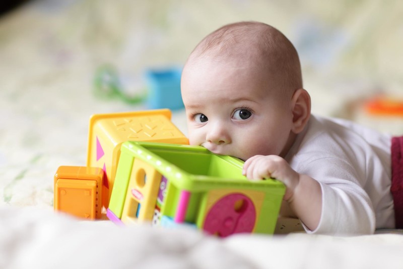 bébé mord un jouet à la crèche