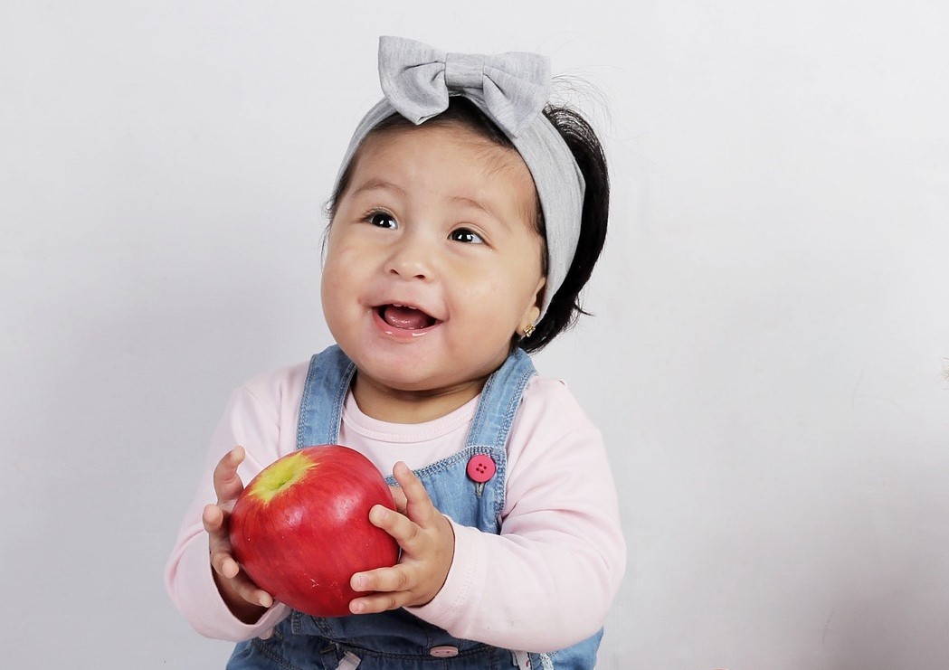 petite fille qui mange une pomme