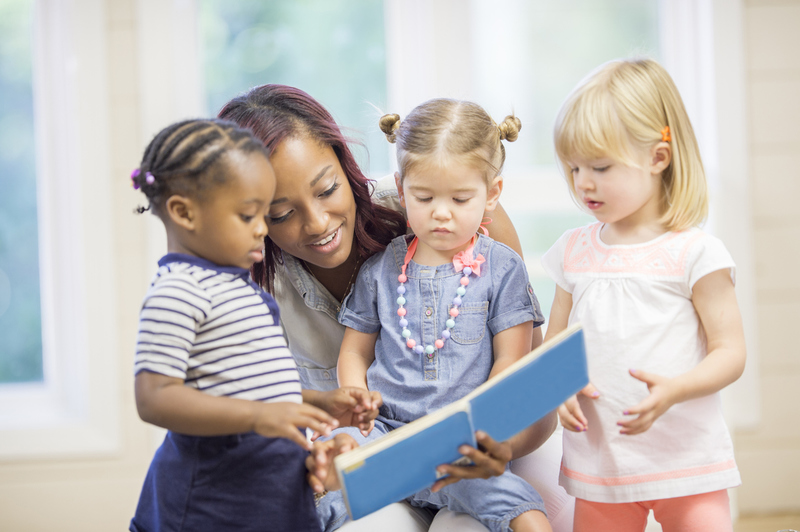 enfants à la crèche avec adulte qui lit une histoire 