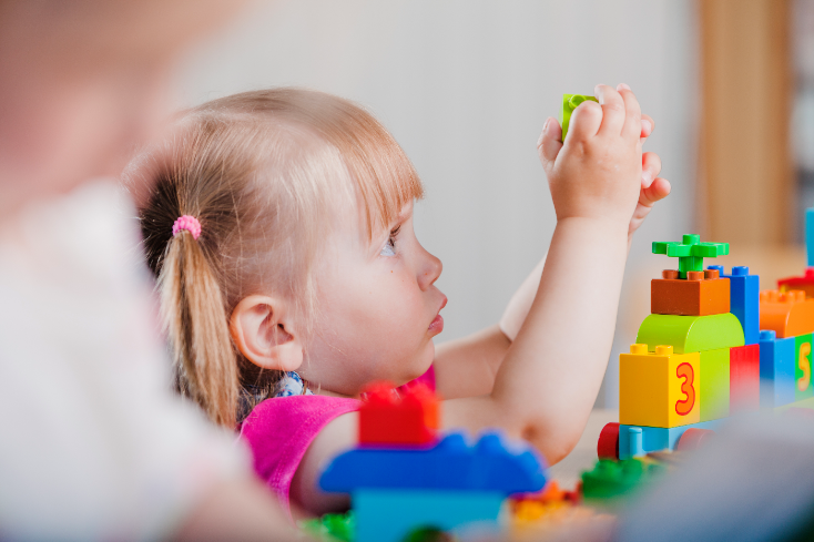 petite fille qui fait un jeu de construction