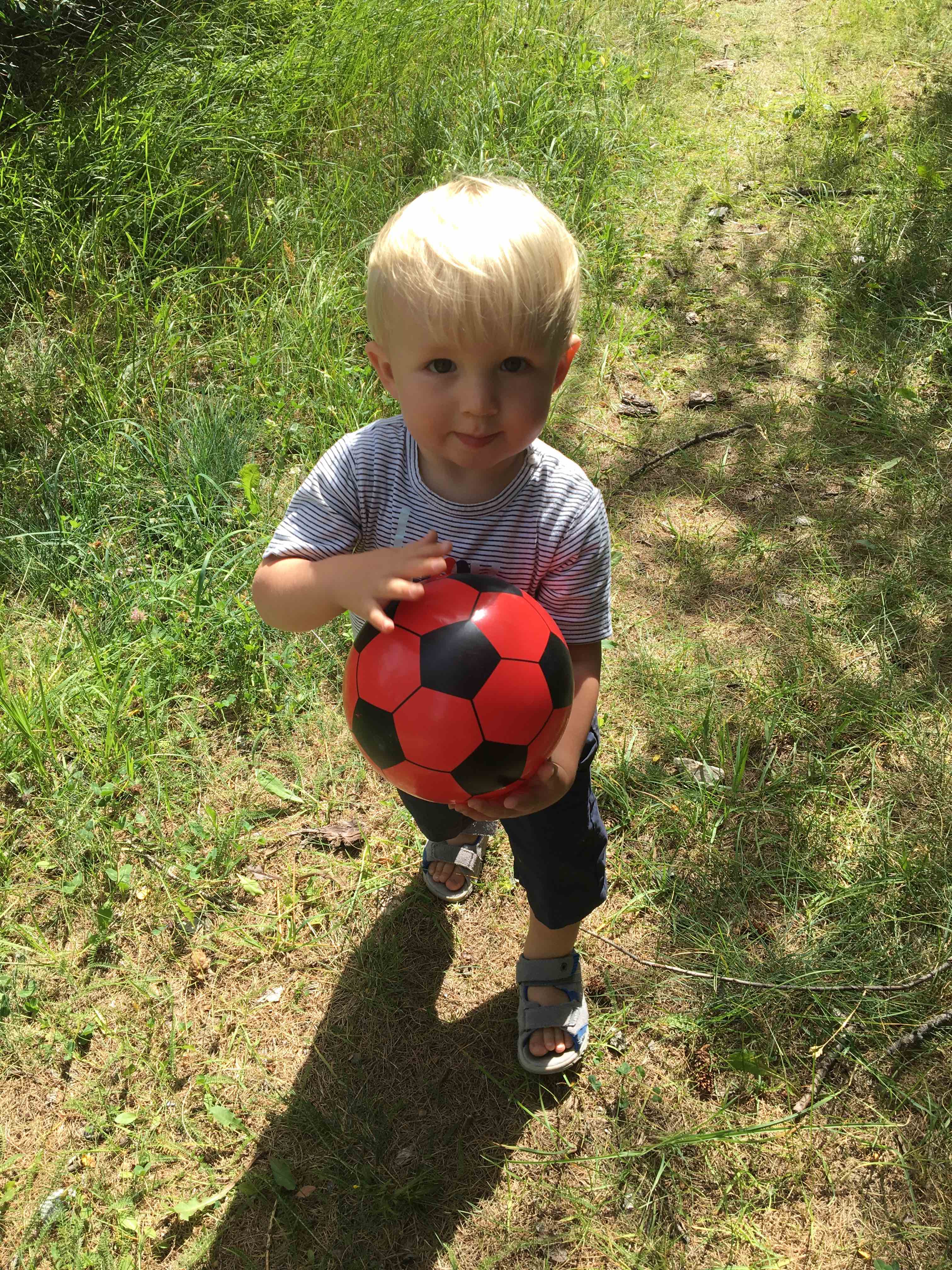 petit garàçpn joue avec ballon