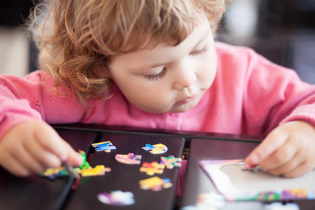 petite fille jouant au puzzle