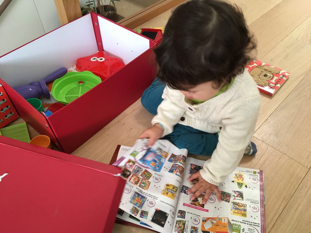 Petite fille avec un catalogue de jouets