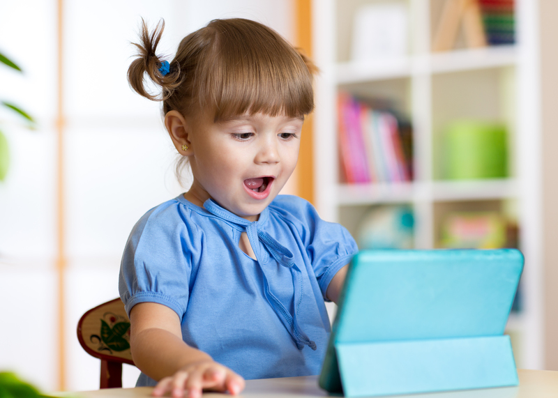 Une petite fille est sidérée devant une tablette