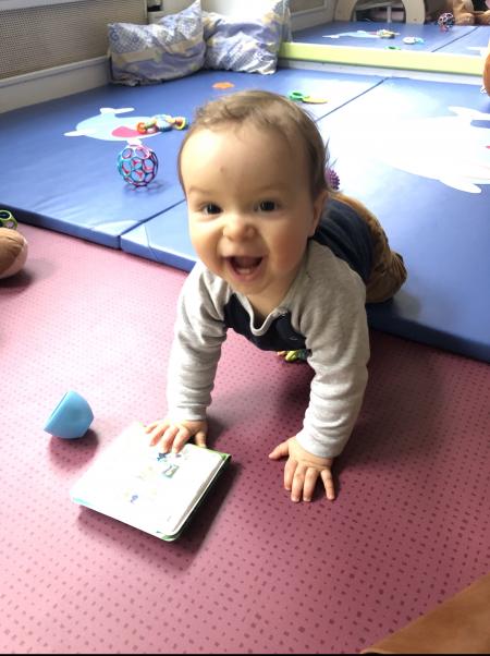 petit garçon joue sur un tapis en crèche