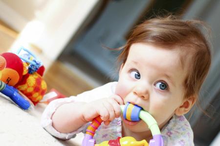 Bébé qui met un jouet à sa bouche