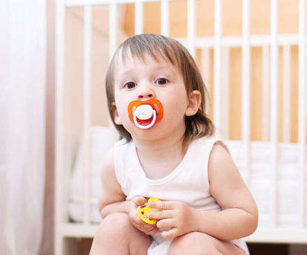 enfant avec tétine dans la bouche