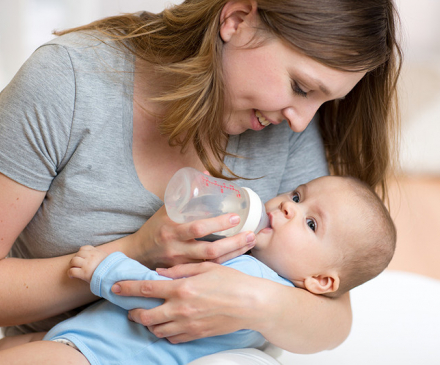 femme qui donne le biberon à un bébé