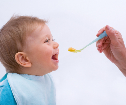 enfant mange premiers morceaux à la cuiller