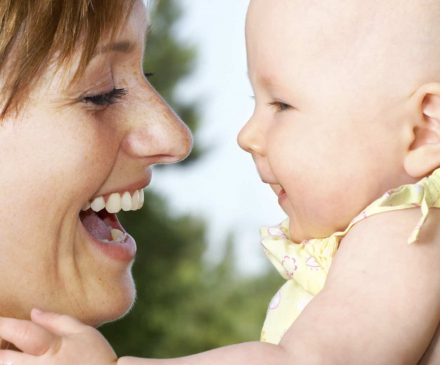 Mère portant son enfant dans ses bras.