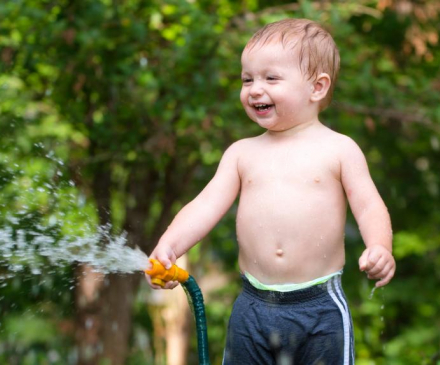 enfant jouant avec un jet d'eau