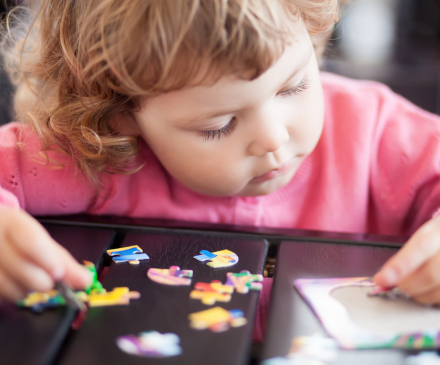 petite fille jouant au puzzle