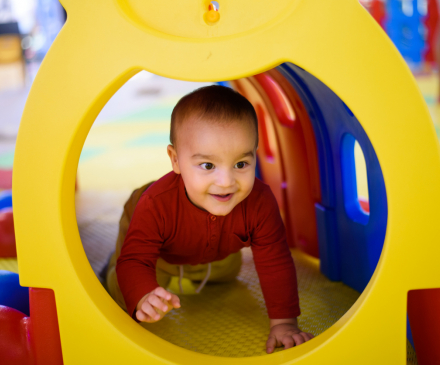 enfant joue dans tunnel  à la crèche