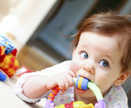 Bébé qui met un jouet à sa bouche