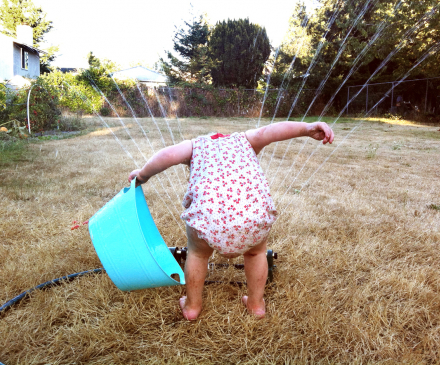 petite fille joue avec l'eau