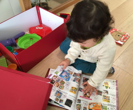 Petite fille avec un catalogue de jouets