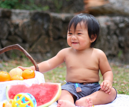 bébé qui participe à un pique-nique riche en fruits