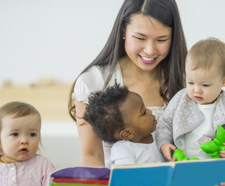 professionnelle lit un  livre à des jeunes enfants