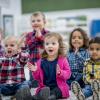 Groupe d'enfants de meternele qui tapent dans leur mains et chantent