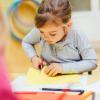 petite fille fait du découpage en classe maternelle