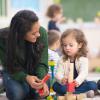 Professionnelle de la petite enfance qui joue avec une petite fille 